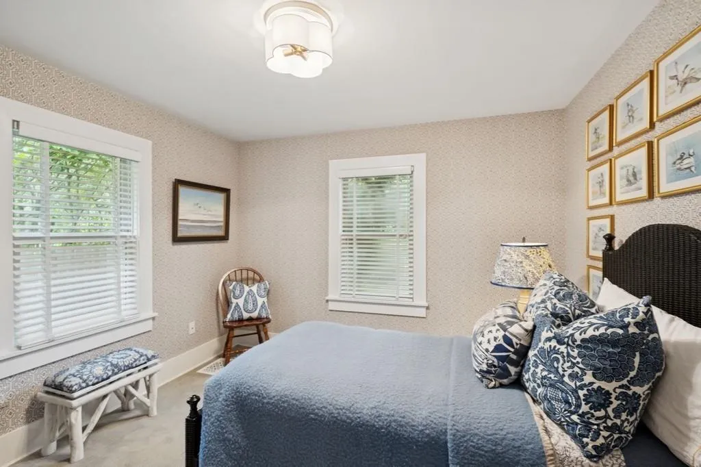 Bedroom with carpet floors and wallpapered walls Bedroom with carpet floors and wallpapered walls