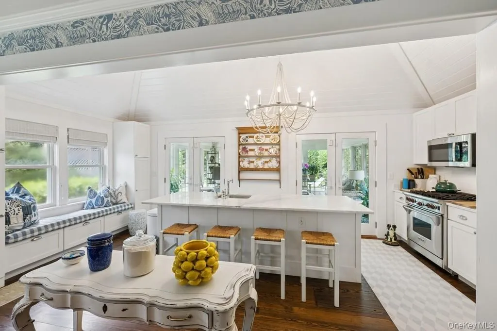 Kitchen featuring appliances with stainless steel finishes, plenty of natural light, dark wood finished floors, a breakfast bar area, and wooden ceiling Kitchen featuring appliances with stainless steel finishes, plenty of natural light, dark wood finished floors, a breakfast bar area, and wooden ceiling