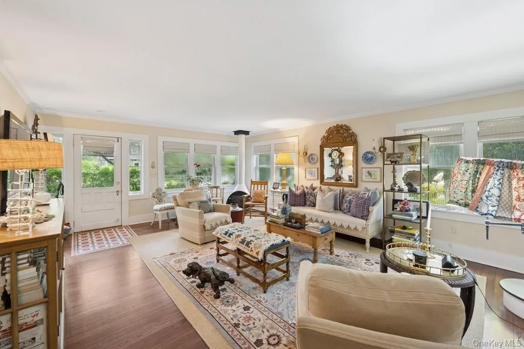 Living room featuring wood finished floors and crown molding Living room featuring wood finished floors and crown molding