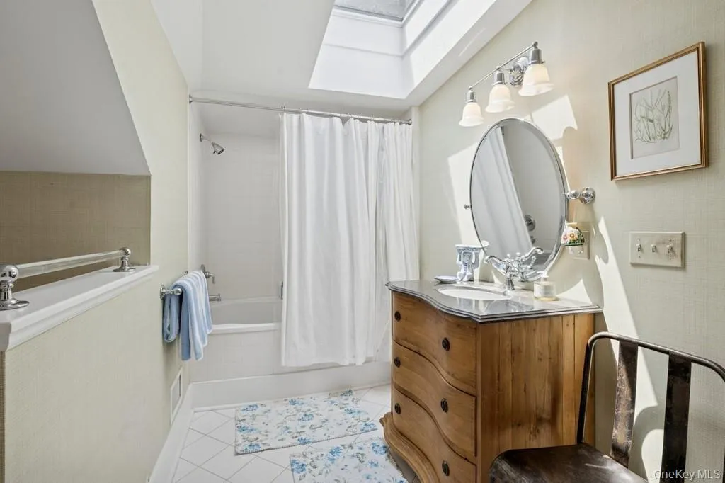 Master Bathroom with a skylight, tile patterned flooring, vanity, and shower / tub combo Master Bathroom with a skylight, tile patterned flooring, vanity, and shower / tub combo