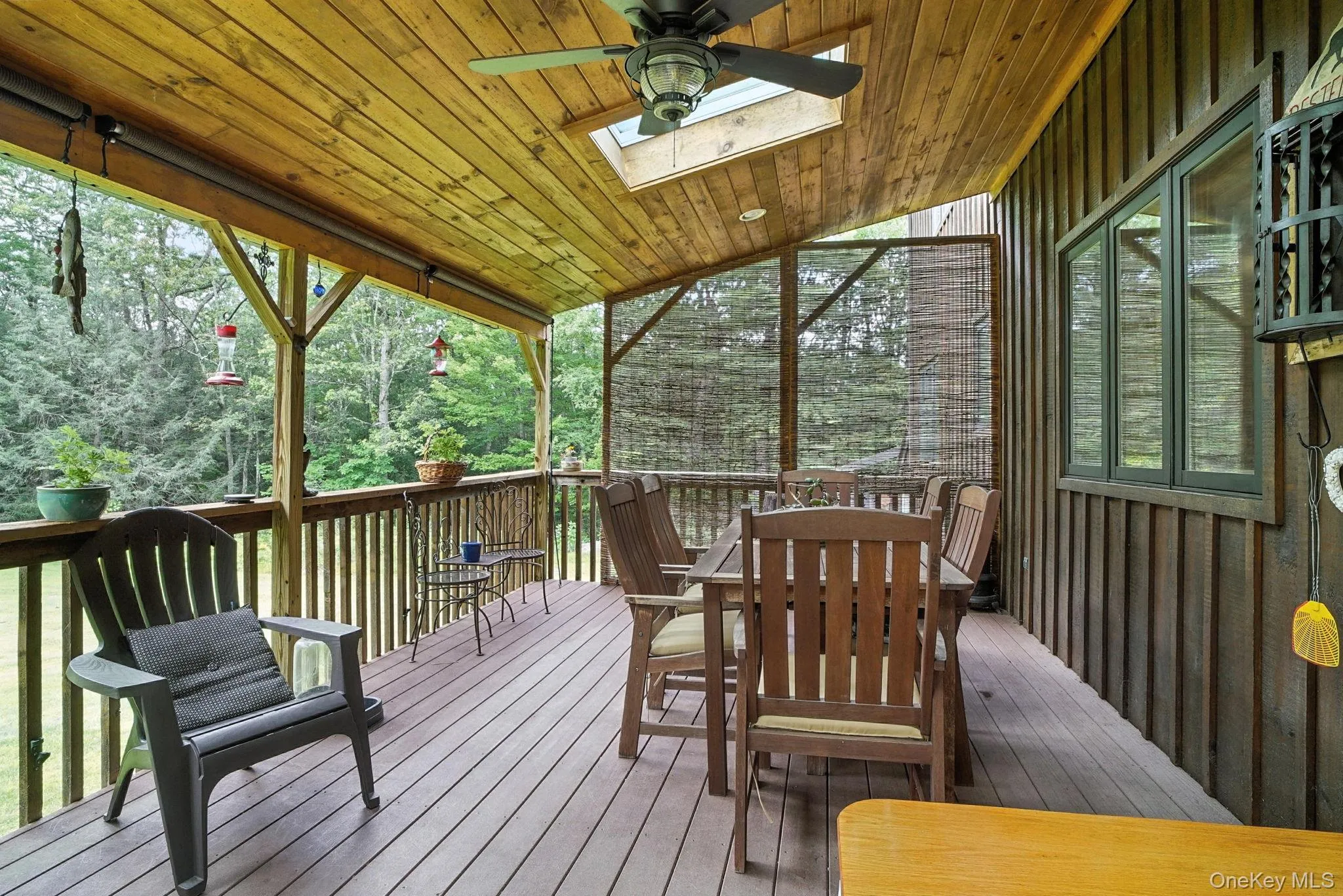 Wooden terrace featuring outdoor dining area, sky lights and ceiling fan Wooden terrace featuring outdoor dining area, sky lights and ceiling fan