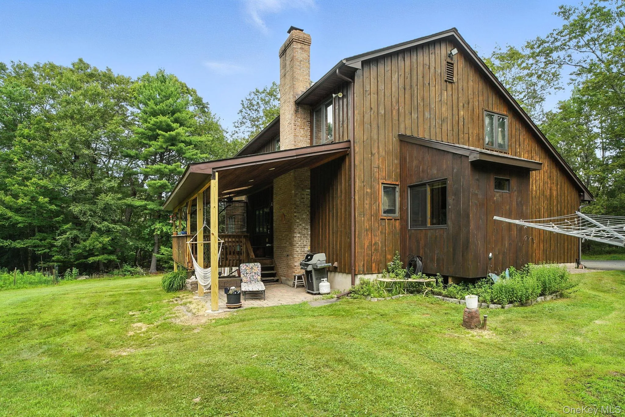 Back of property featuring a chimney, a lawn, and a patio Back of property featuring a chimney, a lawn, and a patio