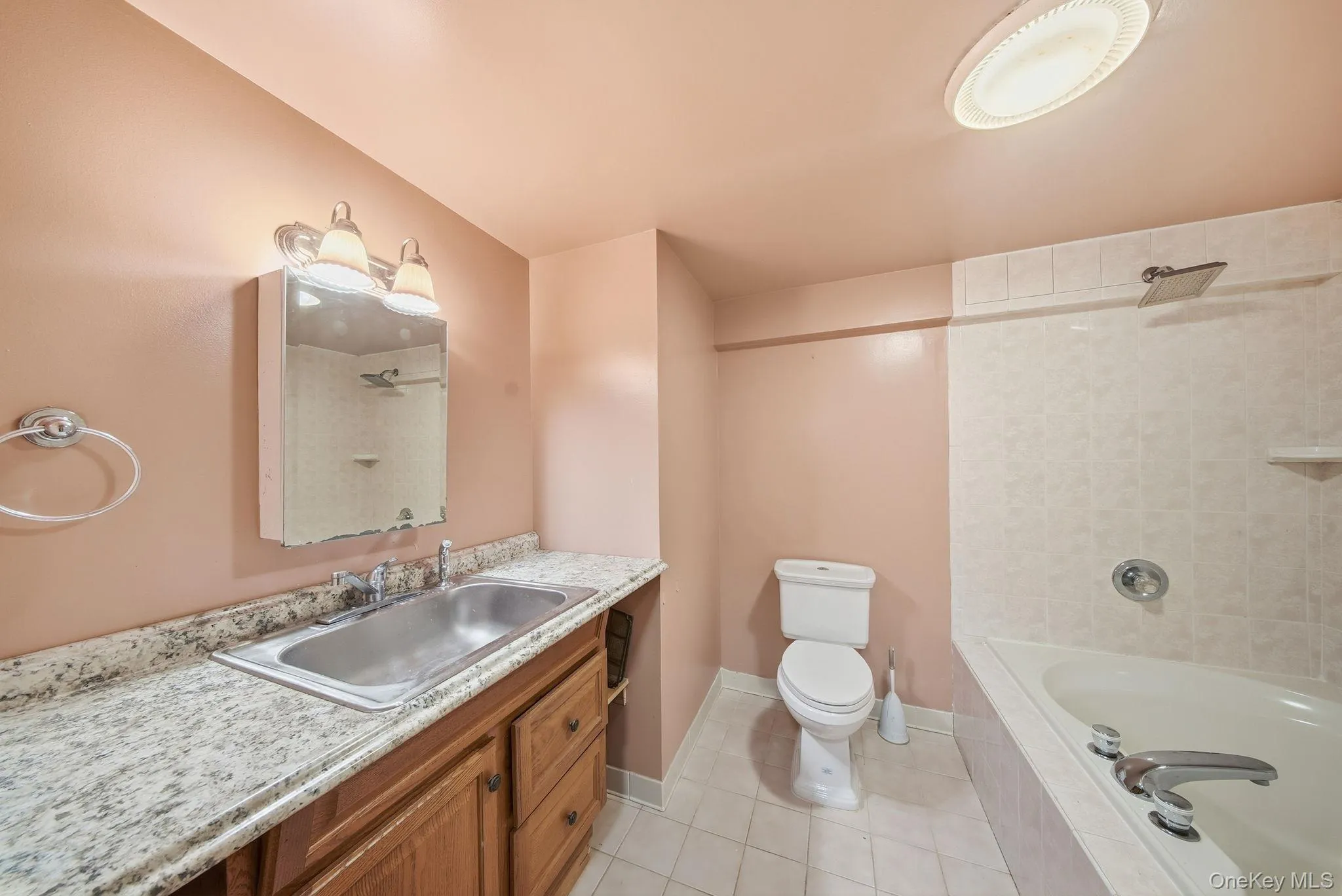 Bathroom featuring vanity, light tile patterned flooring, and tiled shower / bath combo Bathroom featuring vanity, light tile patterned flooring, and tiled shower / bath combo