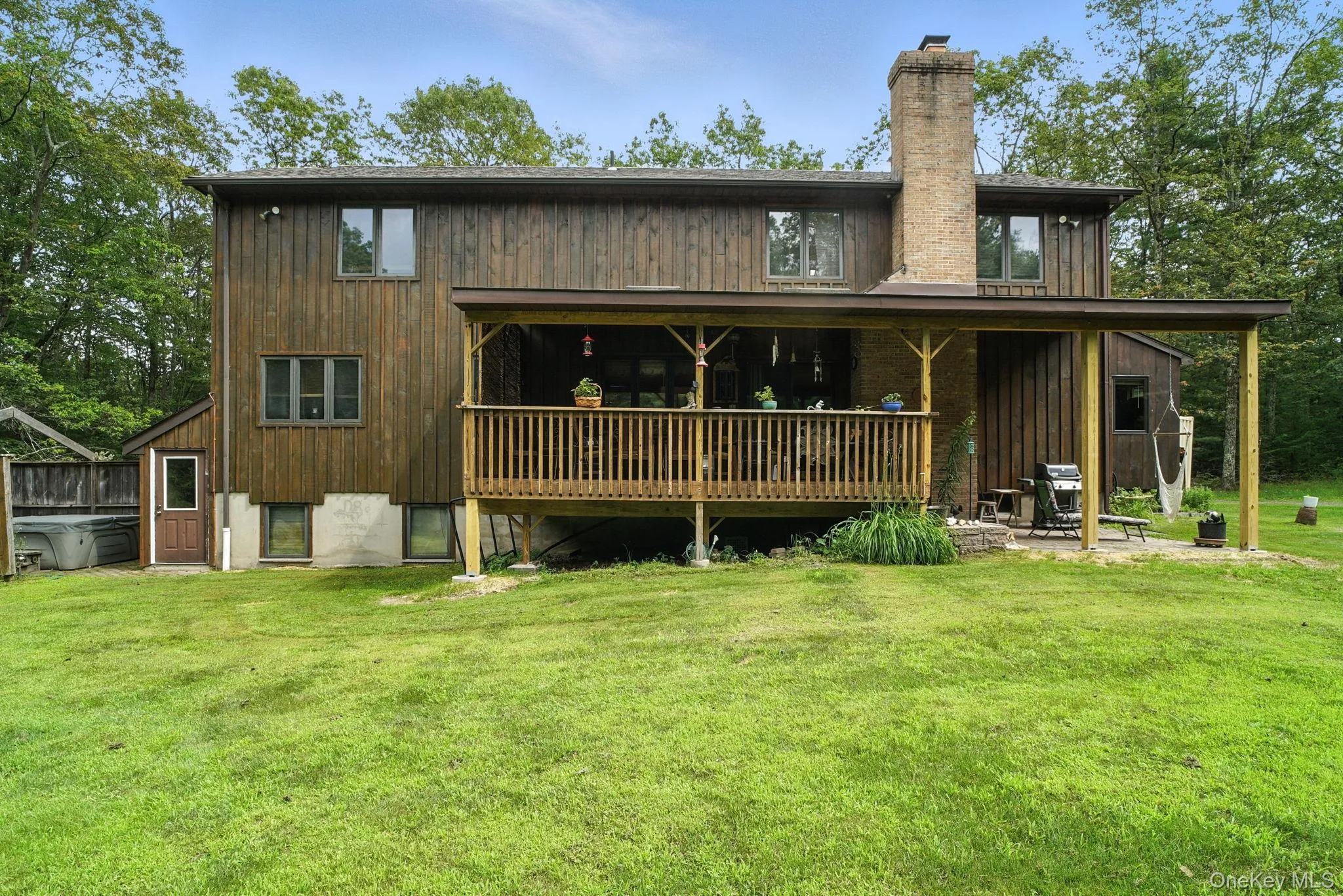 Back of house featuring a lawn and a chimney Back of house featuring a lawn and a chimney