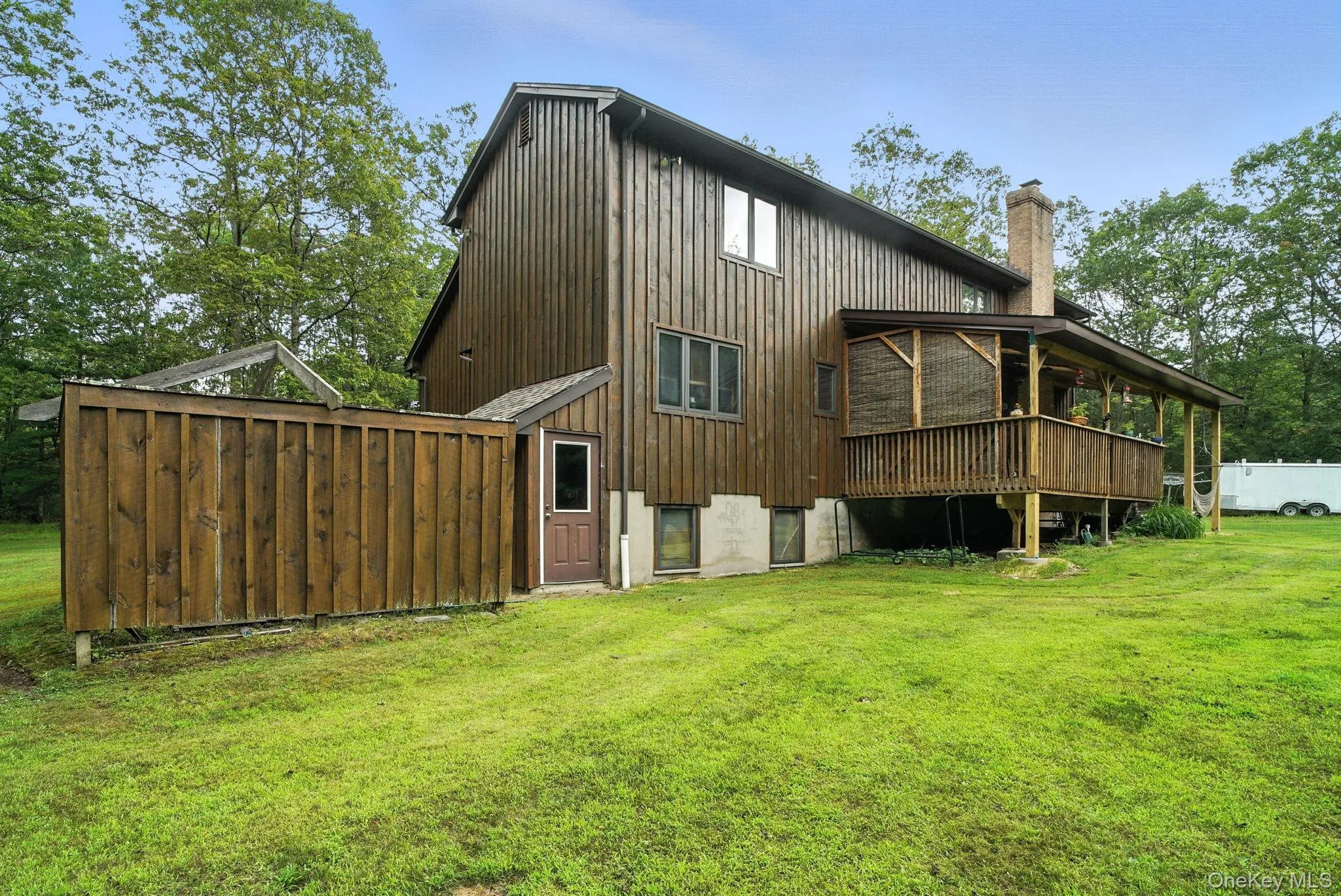 Rear view of property featuring a chimney and a lawn Rear view of property featuring a chimney and a lawn