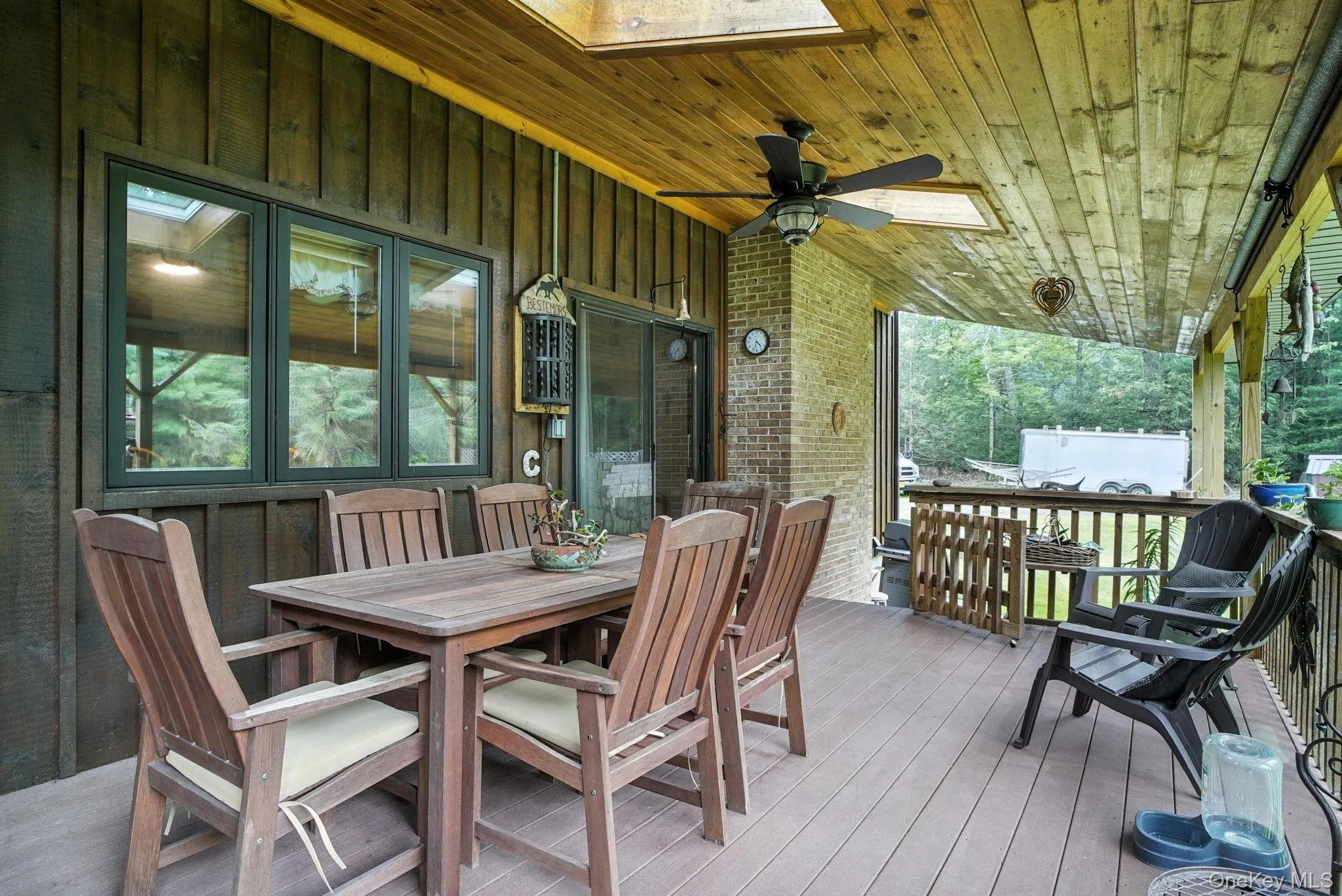 Large Wooden deck featuring a ceiling fan and outdoor dining area Large Wooden deck featuring a ceiling fan and outdoor dining area