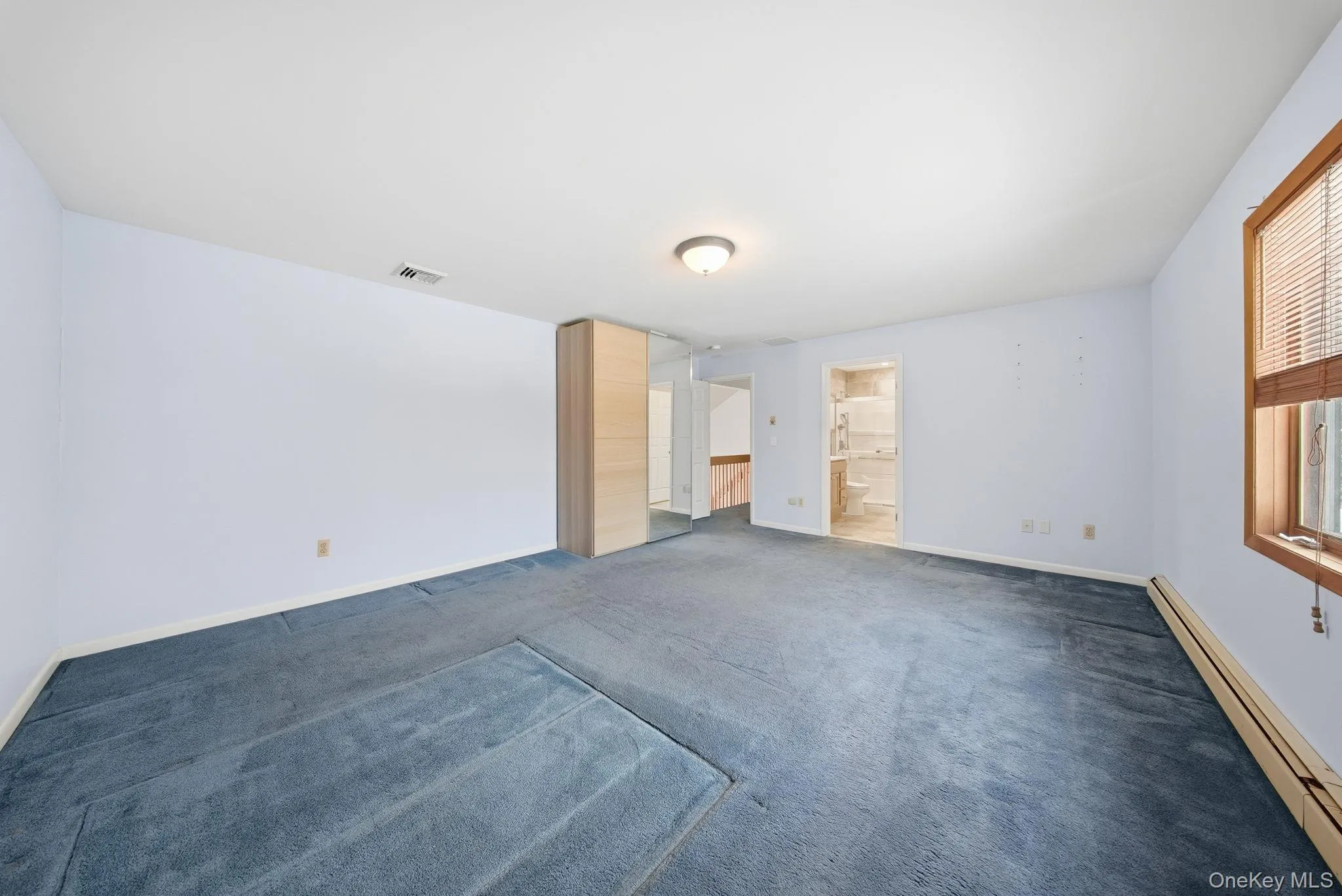 Unfurnished room featuring baseboard heating and carpet flooring Unfurnished room featuring baseboard heating and carpet flooring