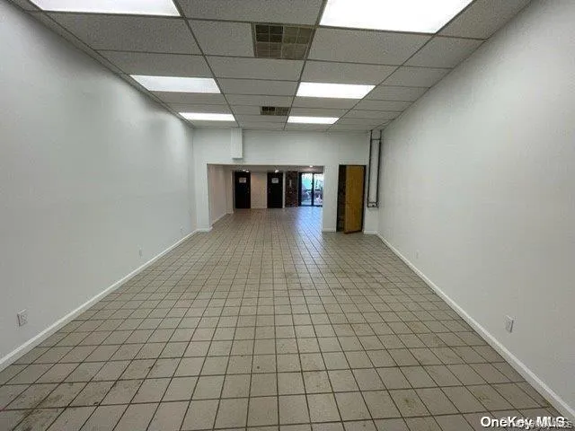 Empty room featuring a drop ceiling and baseboards Empty room featuring a drop ceiling and baseboards