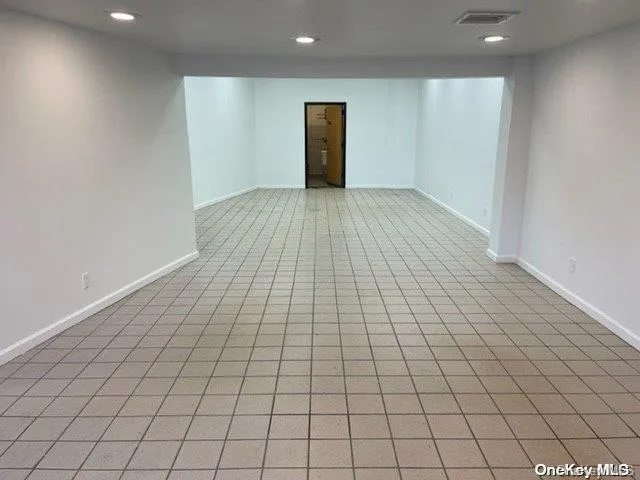 Finished basement with recessed lighting and light tile patterned flooring Finished basement with recessed lighting and light tile patterned flooring