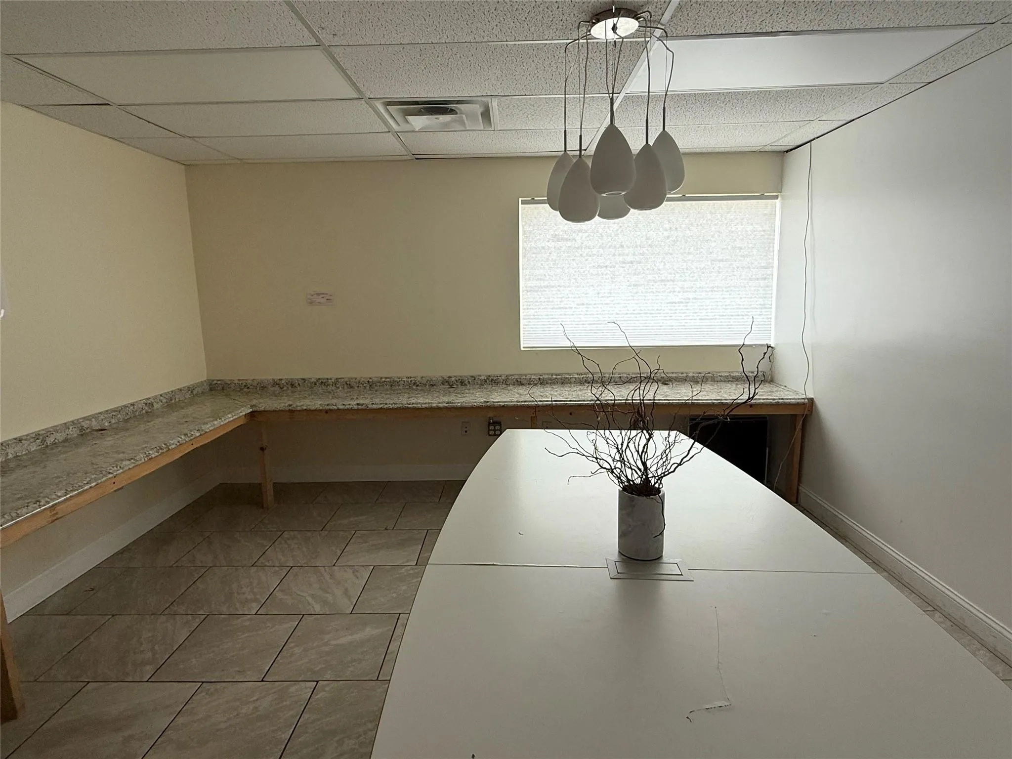 Unfurnished dining area with a drop ceiling and baseboards Unfurnished dining area with a drop ceiling and baseboards