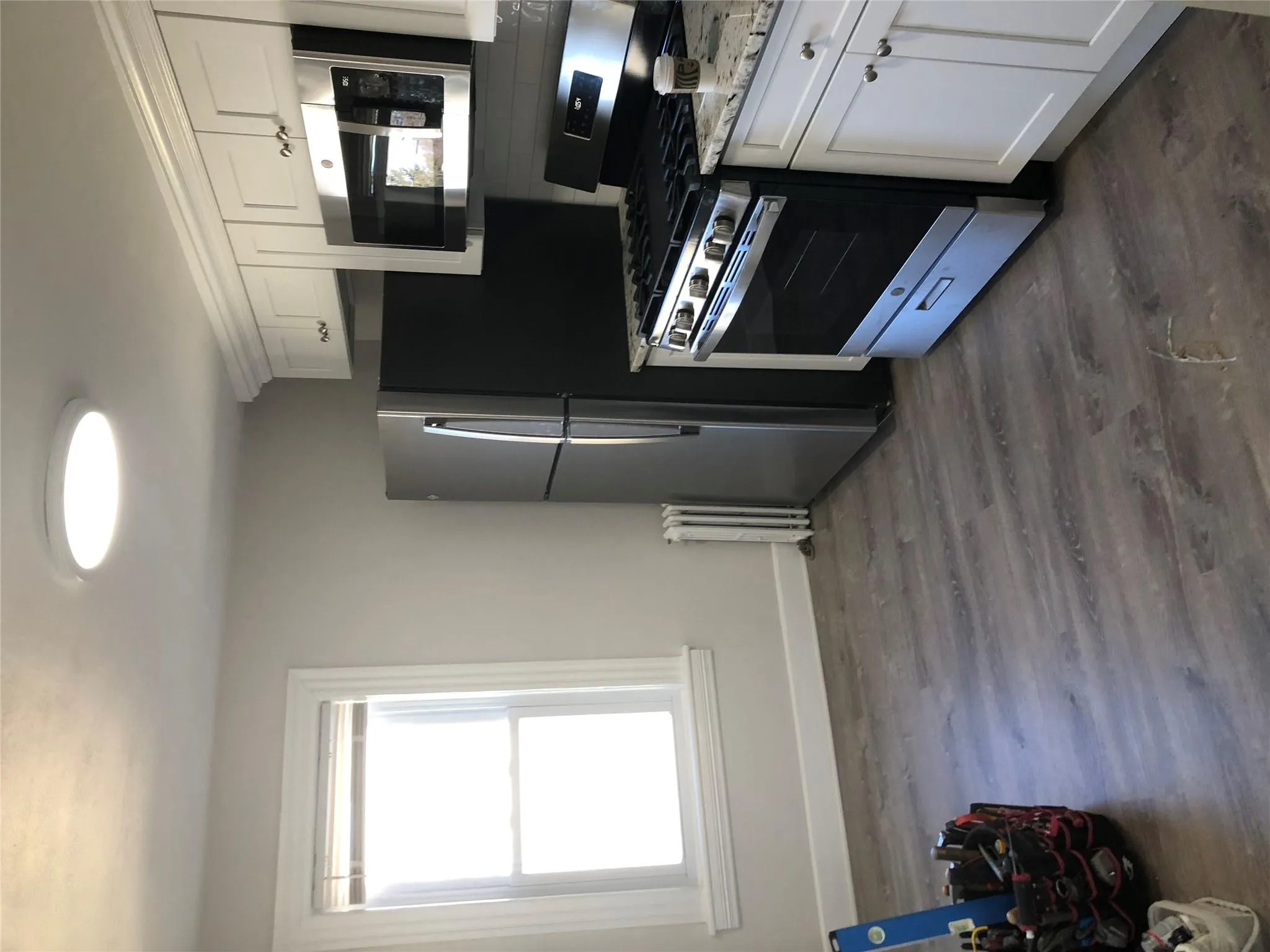 Kitchen with range, radiator heating unit, white cabinetry, dark wood-style floors, and backsplash Kitchen with range, radiator heating unit, white cabinetry, dark wood-style floors, and backsplash