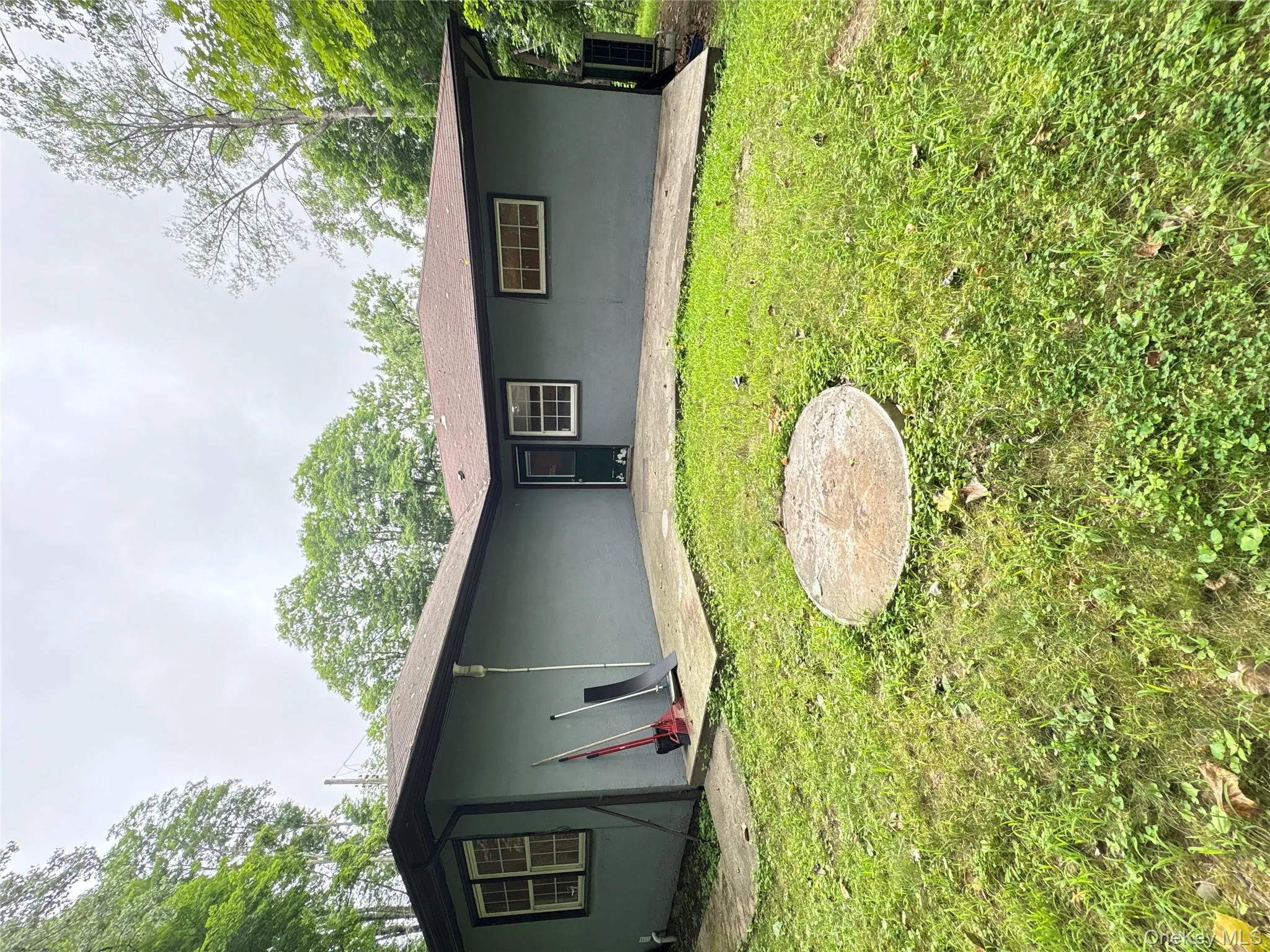 Rear view of house with stucco siding and a lawn Rear view of house with stucco siding and a lawn