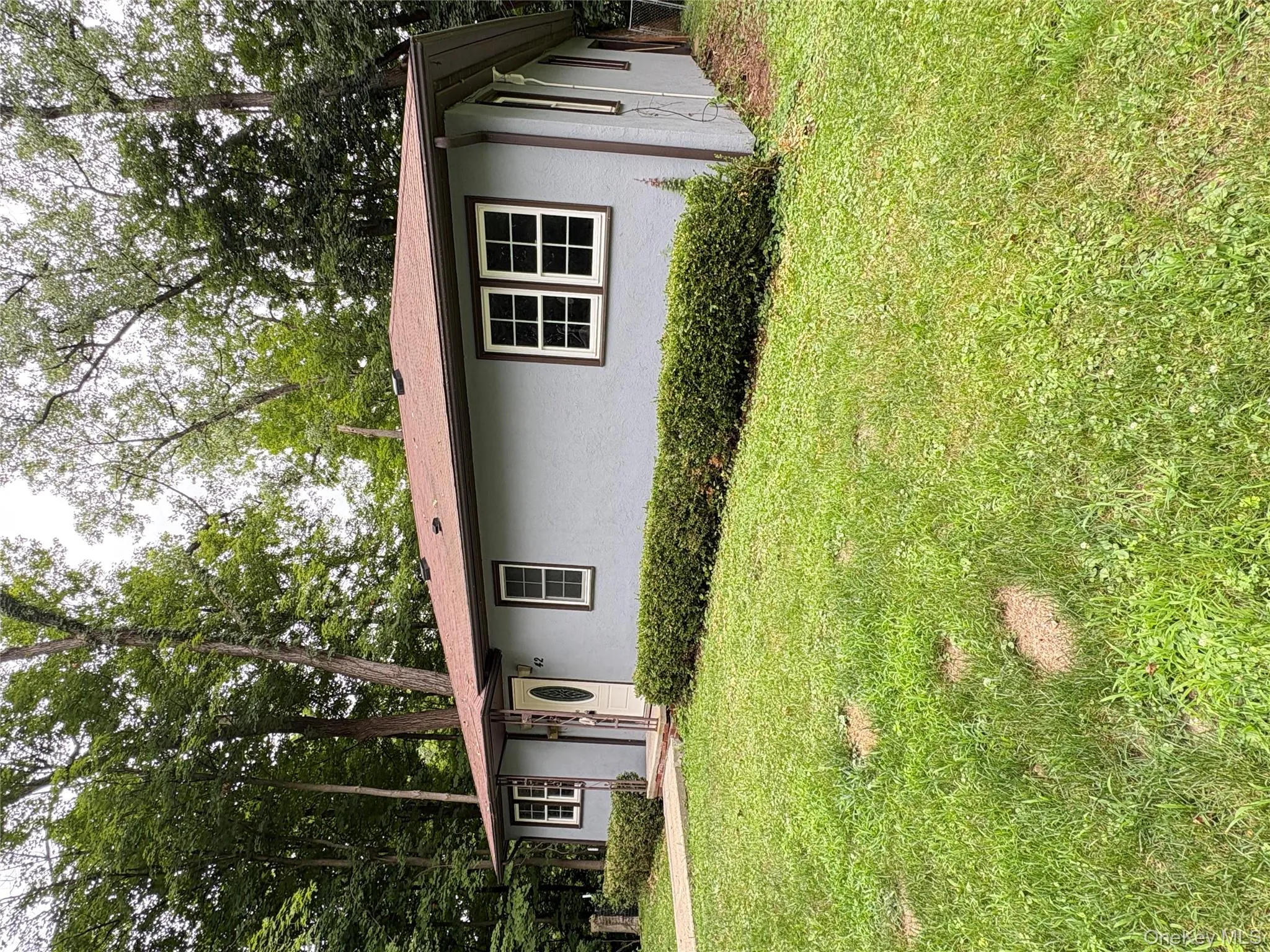 Single story home featuring stucco siding and a front yard Single story home featuring stucco siding and a front yard