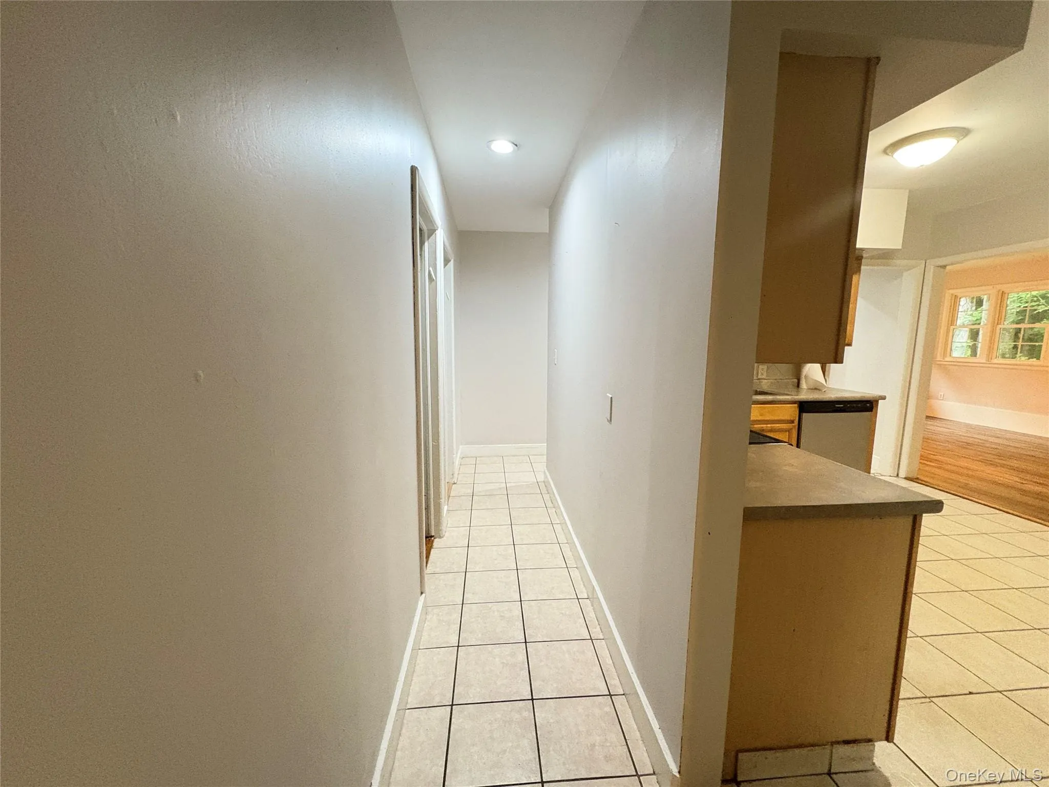 Corridor featuring light tile patterned floors and recessed lighting Corridor featuring light tile patterned floors and recessed lighting