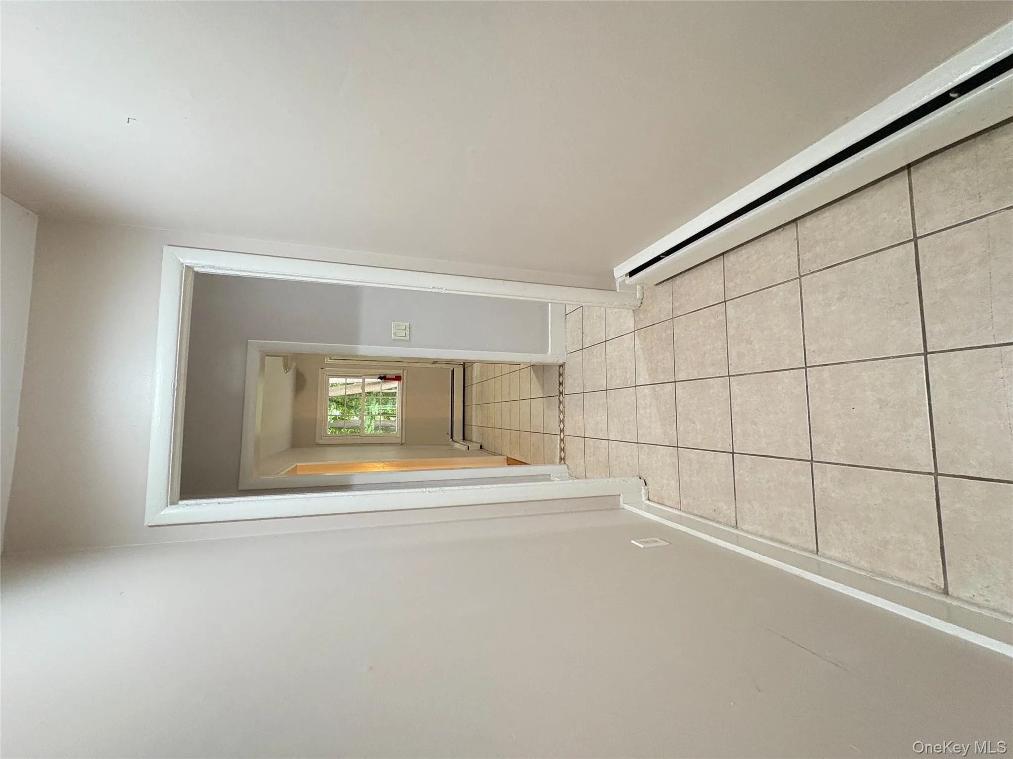 Corridor with a baseboard radiator and light tile patterned floors Corridor with a baseboard radiator and light tile patterned floors