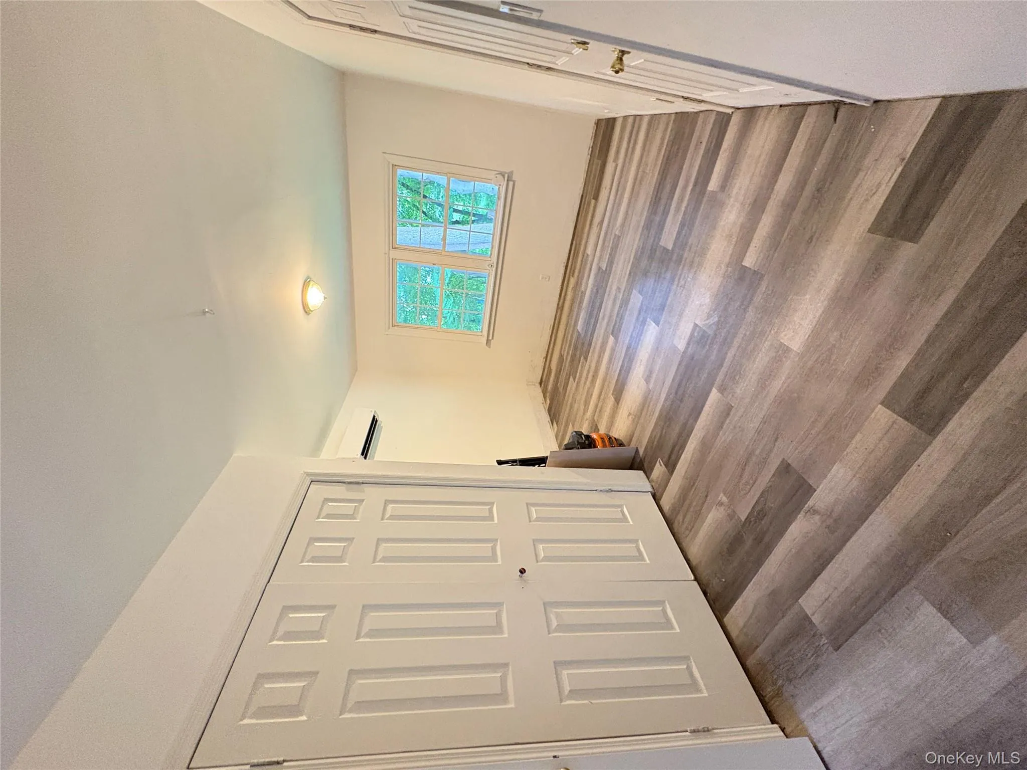 Unfurnished bedroom featuring wood finished floors, an AC wall unit, and a closet Unfurnished bedroom featuring wood finished floors, an AC wall unit, and a closet