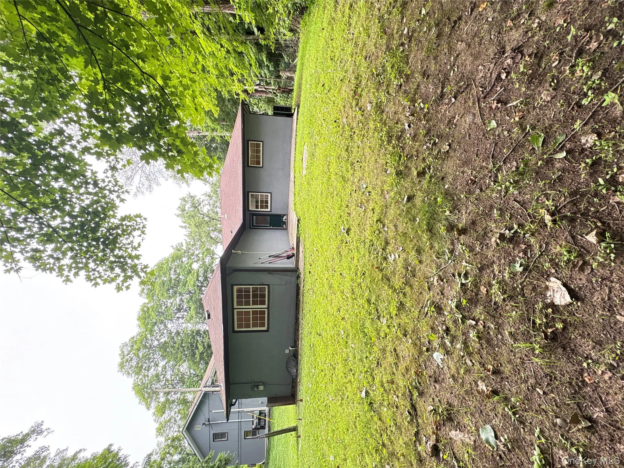 Rear view of house featuring a yard and stucco siding Rear view of house featuring a yard and stucco siding