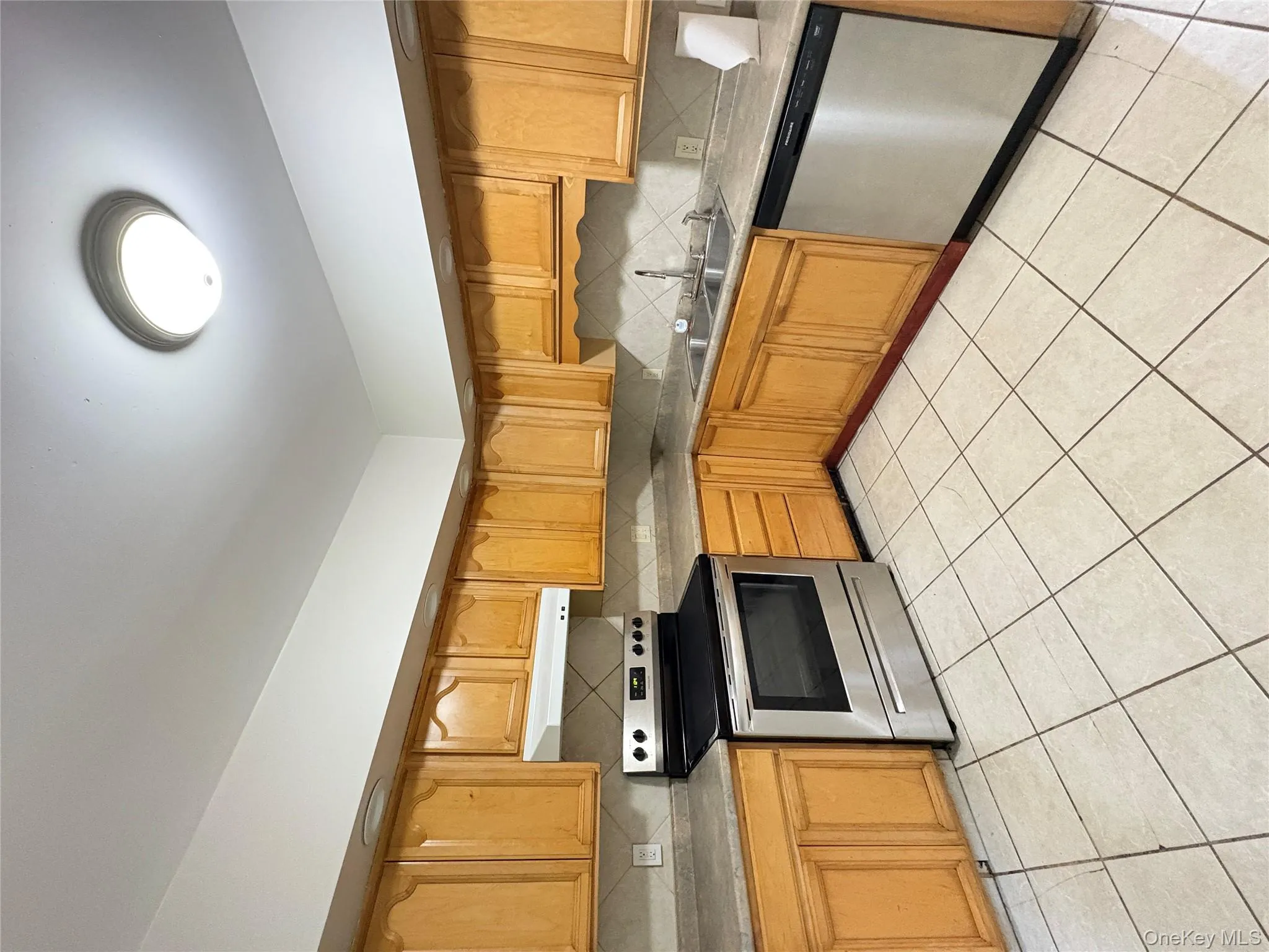 Kitchen featuring dishwashing machine, stove, wall chimney range hood, and decorative backsplash Kitchen featuring dishwashing machine, stove, wall chimney range hood, and decorative backsplash