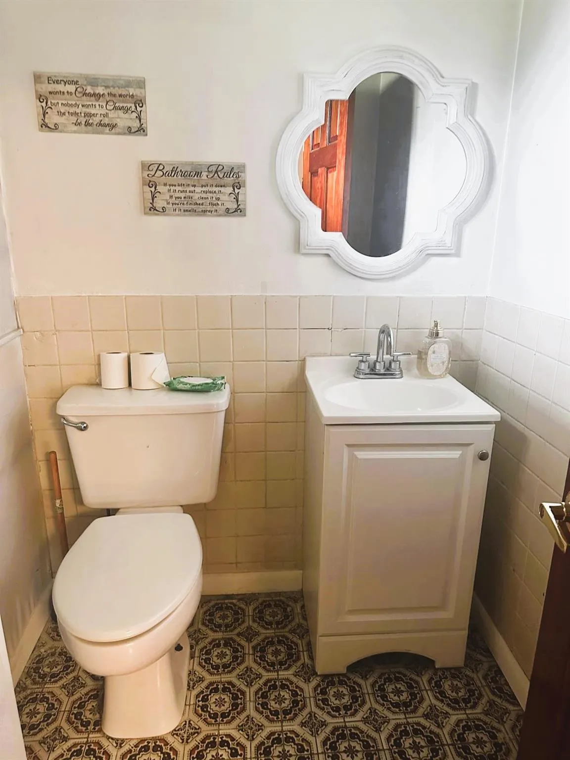 Half bathroom with tile walls, vanity, and a wainscoted wall Half bathroom with tile walls, vanity, and a wainscoted wall