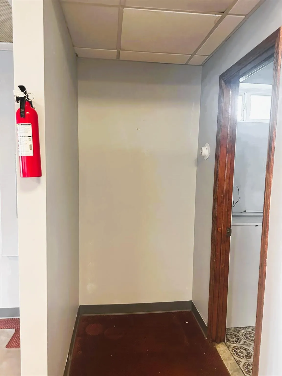 Corridor featuring a drop ceiling and baseboards Corridor featuring a drop ceiling and baseboards