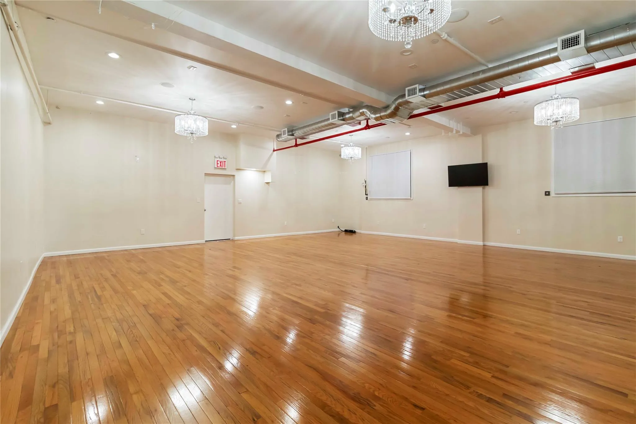 Below grade area with a chandelier, hardwood / wood-style flooring, and recessed lighting Below grade area with a chandelier, hardwood / wood-style flooring, and recessed lighting