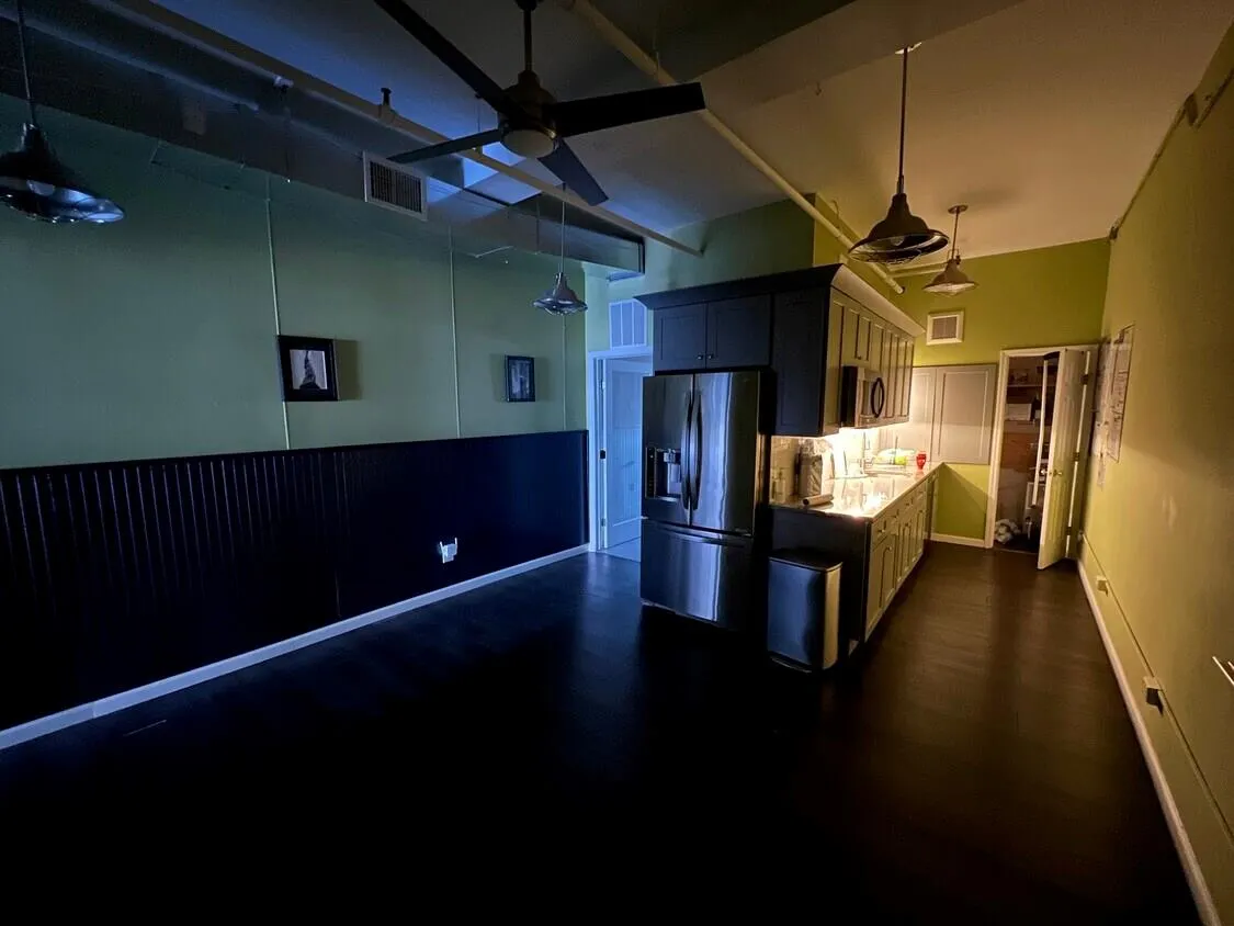 Kitchen with stainless steel appliances, a ceiling fan, dark wood-style floors, hanging light fixtures, and light countertops Kitchen with stainless steel appliances, a ceiling fan, dark wood-style floors, hanging light fixtures, and light countertops