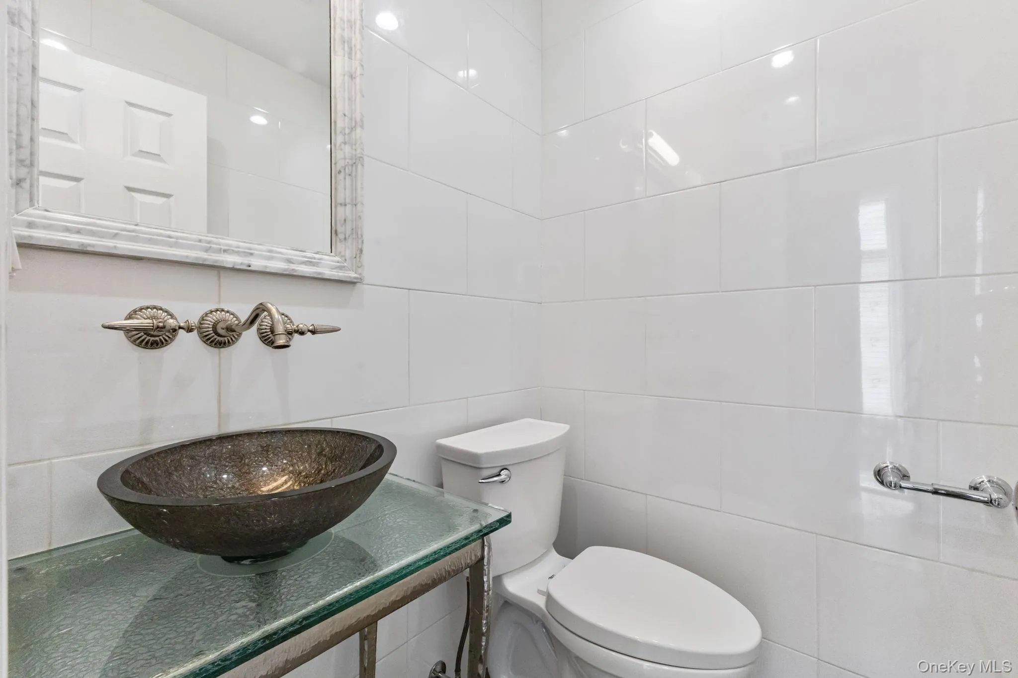 Half bathroom with tile walls and a sink Half bathroom with tile walls and a sink
