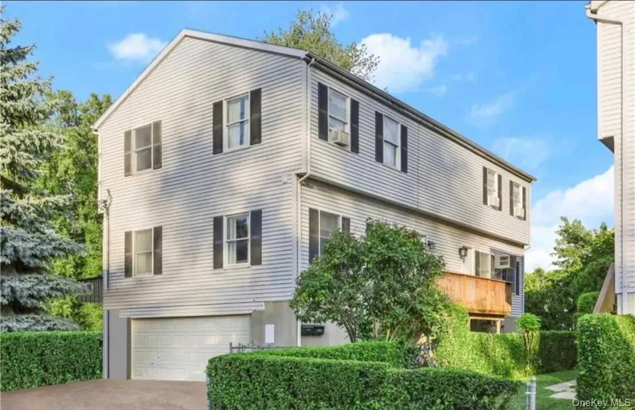 View of side of home featuring concrete driveway and a garage View of side of home featuring concrete driveway and a garage
