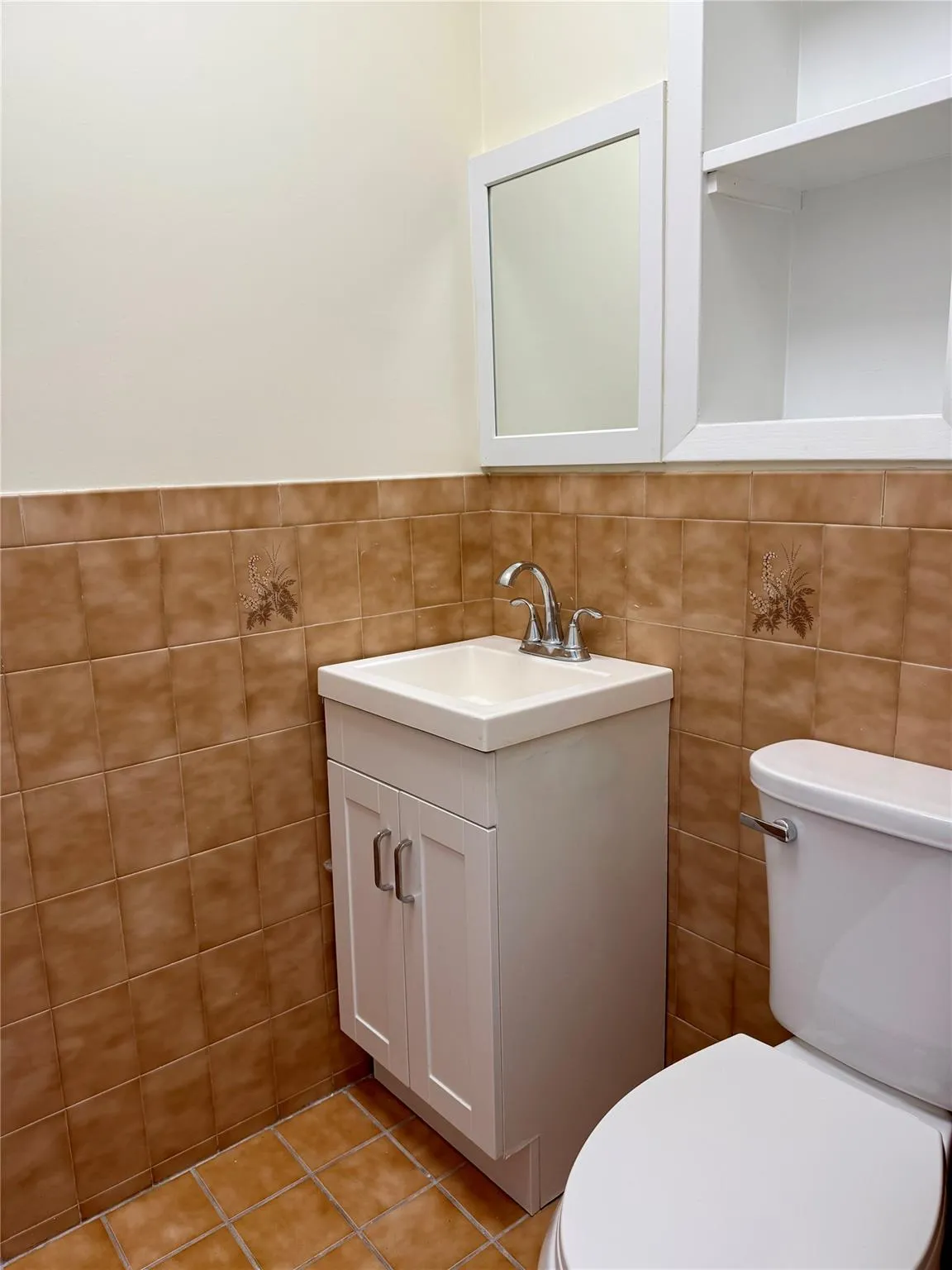 Half bath with vanity, tile walls, and tile patterned flooring Half bath with vanity, tile walls, and tile patterned flooring