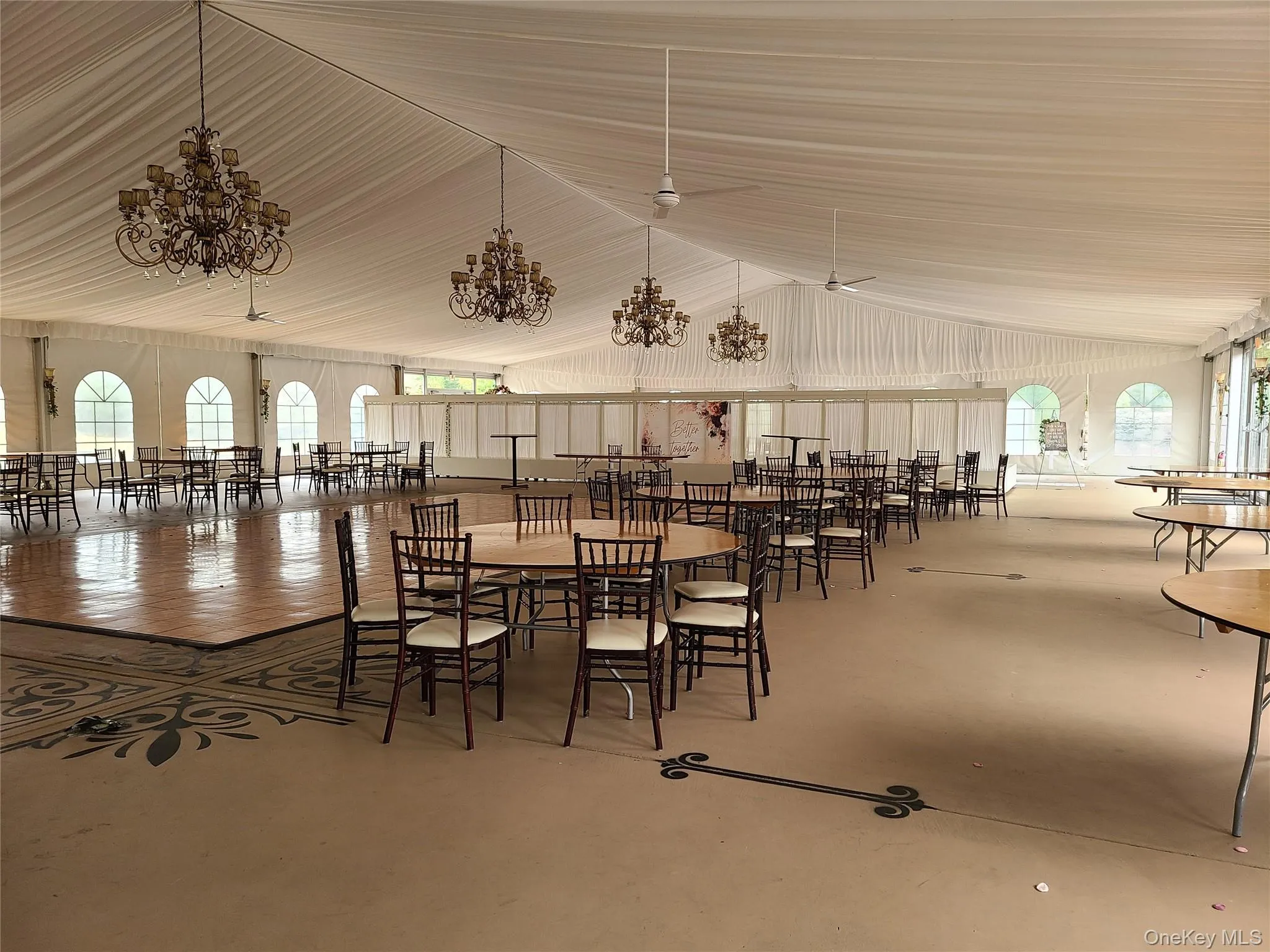 Dining space featuring high vaulted ceiling, concrete flooring, and a chandelier Dining space featuring high vaulted ceiling, concrete flooring, and a chandelier