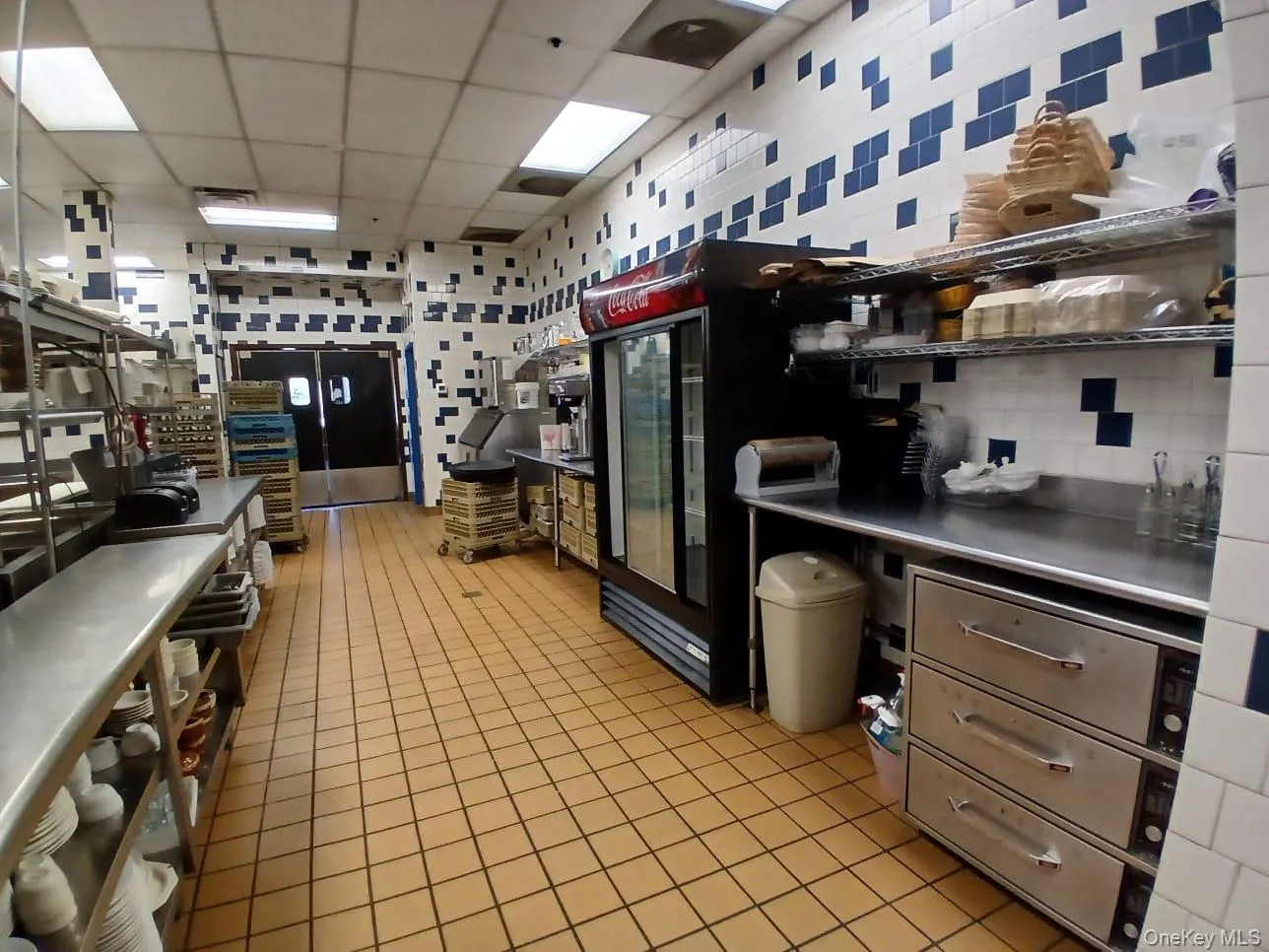 Kitchen with freestanding refrigerator, a drop ceiling, and light tile patterned floors Kitchen with freestanding refrigerator, a drop ceiling, and light tile patterned floors
