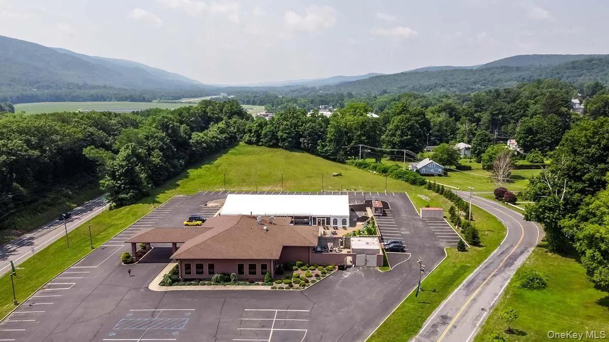 Aerial view of property and surrounding area featuring a mountainous background Aerial view of property and surrounding area featuring a mountainous background