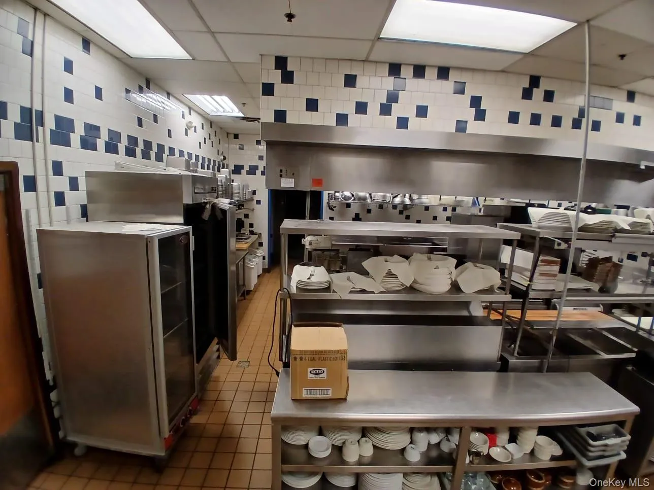 Kitchen featuring tile patterned floors, a paneled ceiling, and tile walls Kitchen featuring tile patterned floors, a paneled ceiling, and tile walls