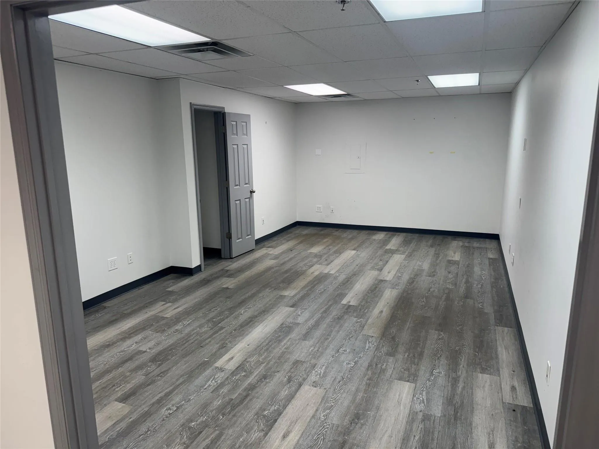 Empty room with wood finished floors and a paneled ceiling Empty room with wood finished floors and a paneled ceiling