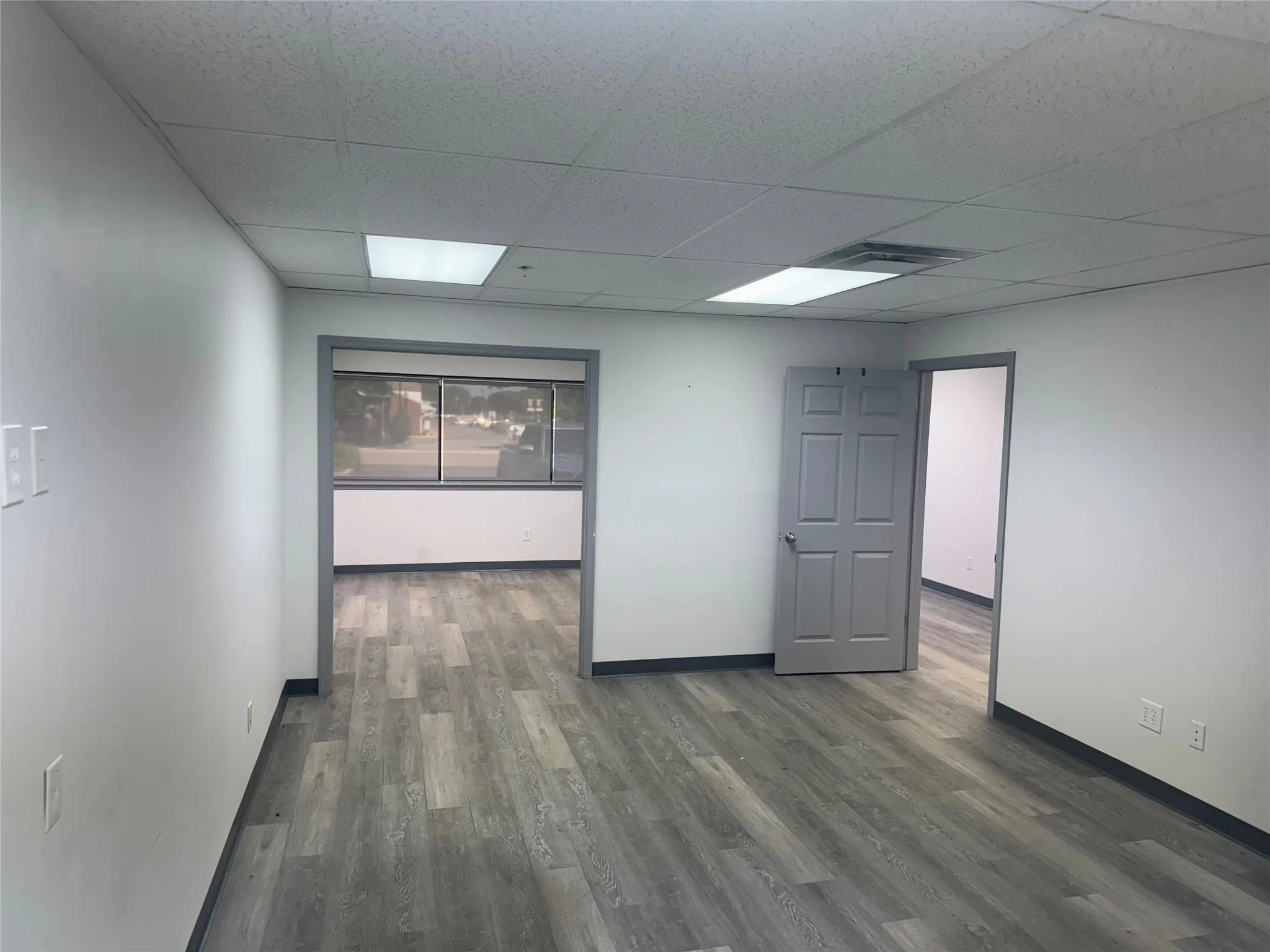 Unfurnished room featuring a paneled ceiling and wood finished floors Unfurnished room featuring a paneled ceiling and wood finished floors