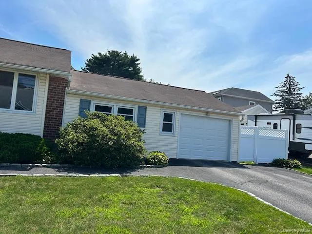 View of side of property featuring an attached garage and driveway View of side of property featuring an attached garage and driveway