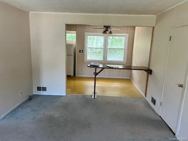 Unfurnished dining area featuring crown molding and carpet floors Unfurnished dining area featuring crown molding and carpet floors