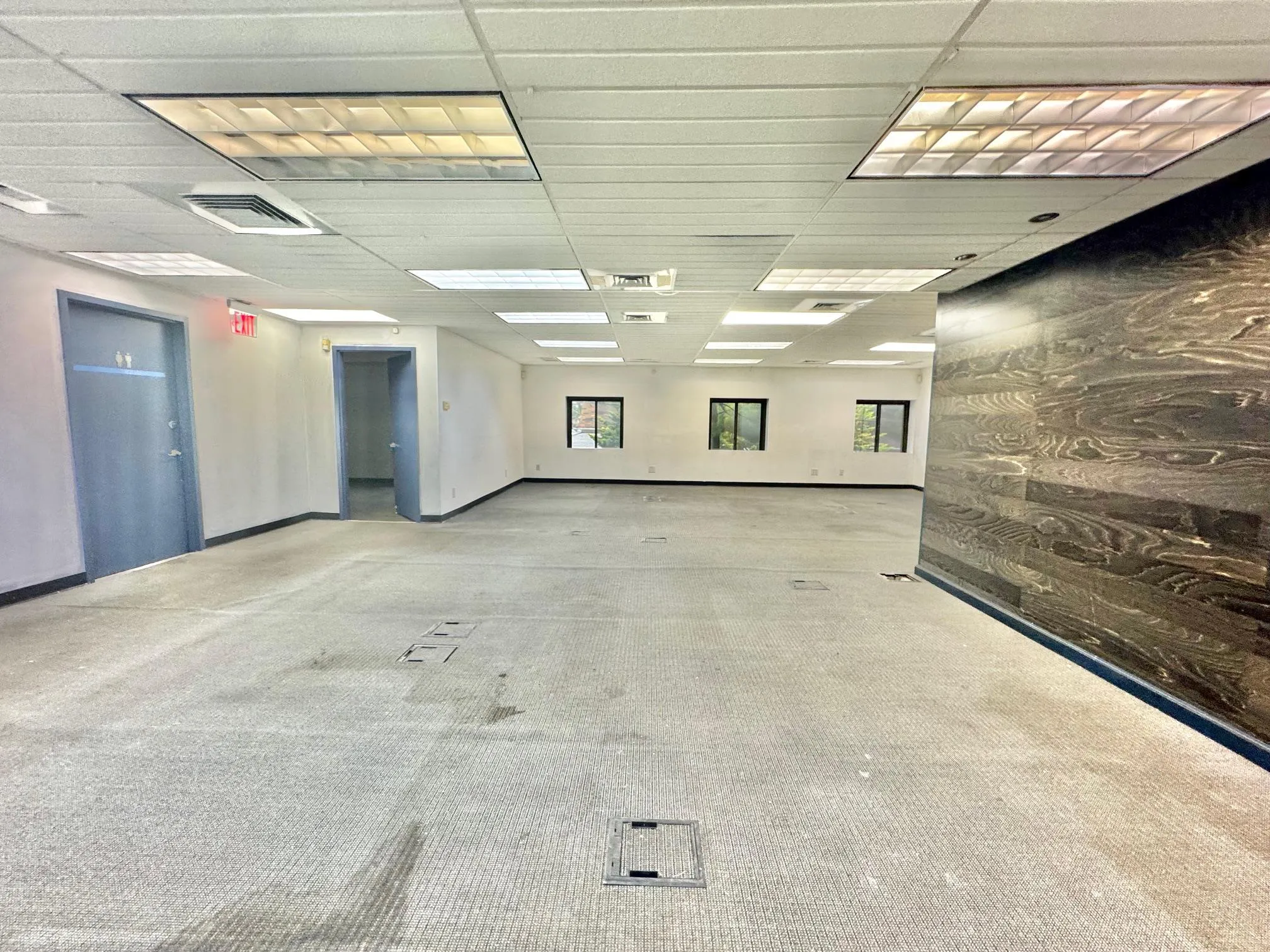 Carpeted spare room featuring healthy amount of natural light and a paneled ceiling Carpeted spare room featuring healthy amount of natural light and a paneled ceiling