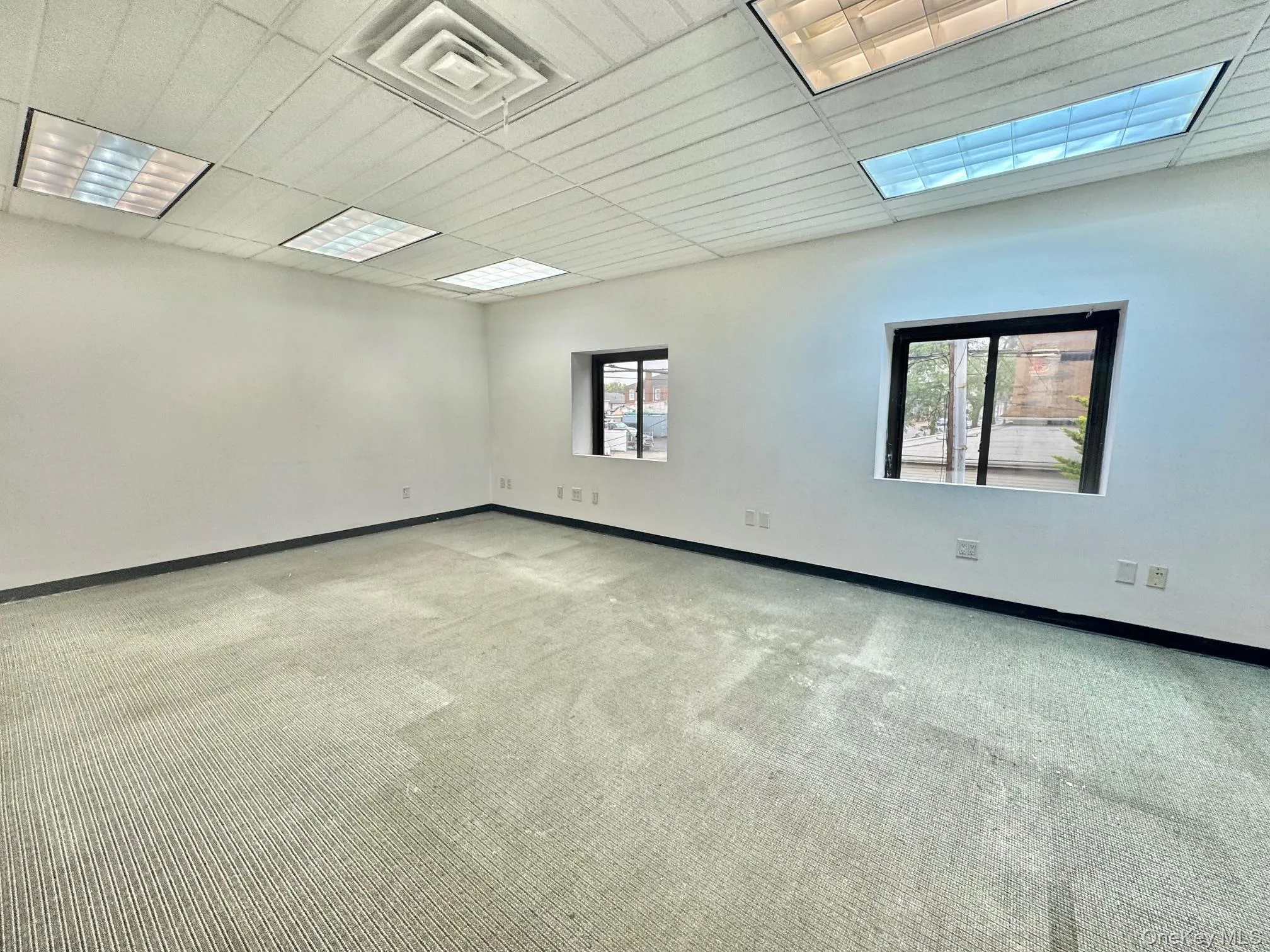 Carpeted empty room with baseboards Carpeted empty room with baseboards