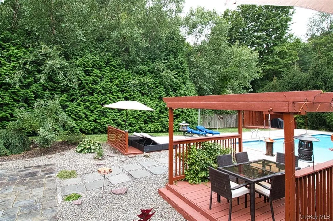 Backyard w/ two pergolas, flagstone patio, wooden sun deck for lounge chairs Backyard w/ two pergolas, flagstone patio, wooden sun deck for lounge chairs