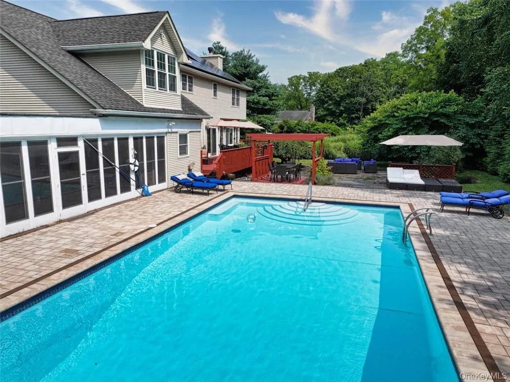 View of swimming pool featuring a pool house (to the left in photo) View of swimming pool featuring a pool house (to the left in photo)