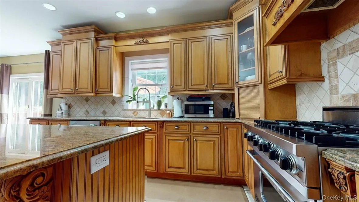 Kitchen with upscale appliances (stainless steel) such as Bosch and Viking.Double sink under window, and deep prep sink in island,decorative backsplash, and granite counters. Kitchen with upscale appliances (stainless steel) such as Bosch and Viking.Double sink under window, and deep prep sink in island,decorative backsplash, and granite counters.