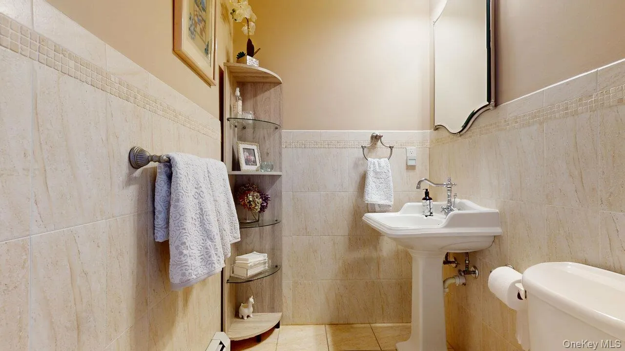 Bathroom featuring tile walls, tile patterned flooring, and wainscoting Bathroom featuring tile walls, tile patterned flooring, and wainscoting