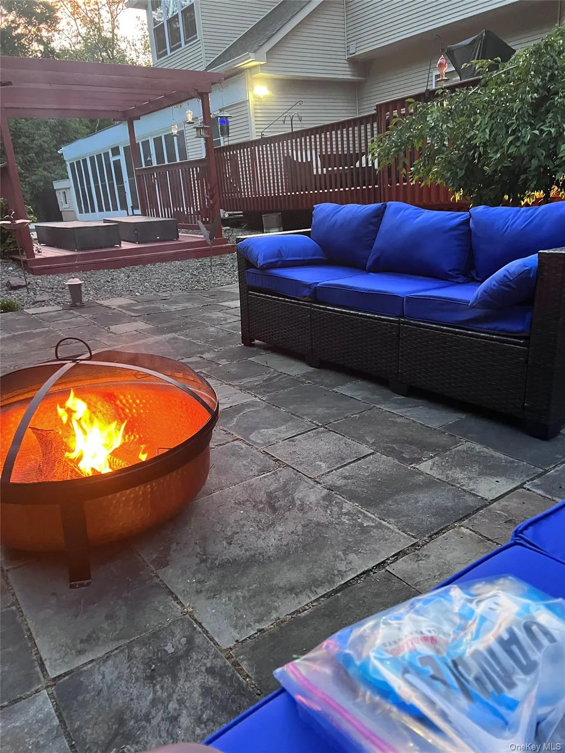View of flagstone patio featuring an outdoor living space with a fire pit and a deck View of flagstone patio featuring an outdoor living space with a fire pit and a deck