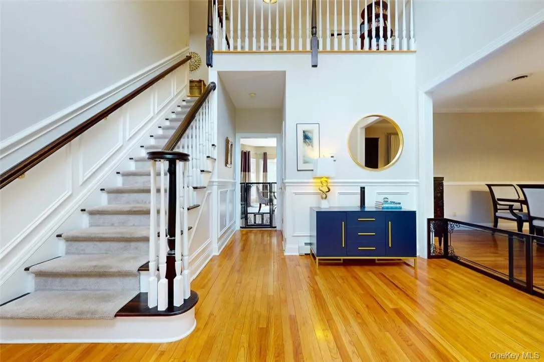 Dramatic foyer, with vauled ceiling,large chandelier, inlaid wood floors, custom mouldings on walls , upgraded staircase , beautiful Palladium window for lots of light Dramatic foyer, with vauled ceiling,large chandelier, inlaid wood floors, custom mouldings on walls , upgraded staircase , beautiful Palladium window for lots of light