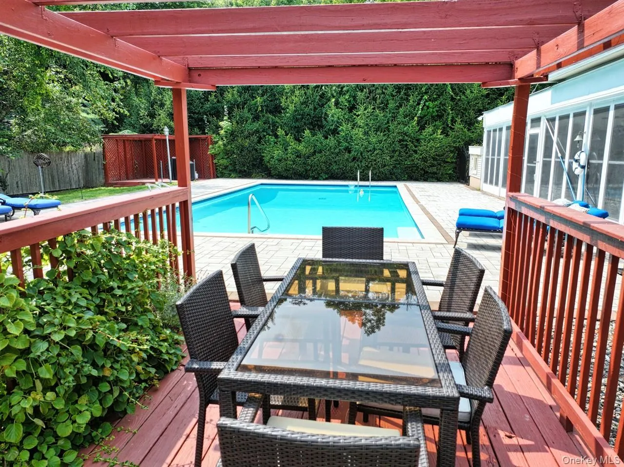View of pool featuring a deck, two pergolas, a fenced backyard, and outdoor dining area View of pool featuring a deck, two pergolas, a fenced backyard, and outdoor dining area