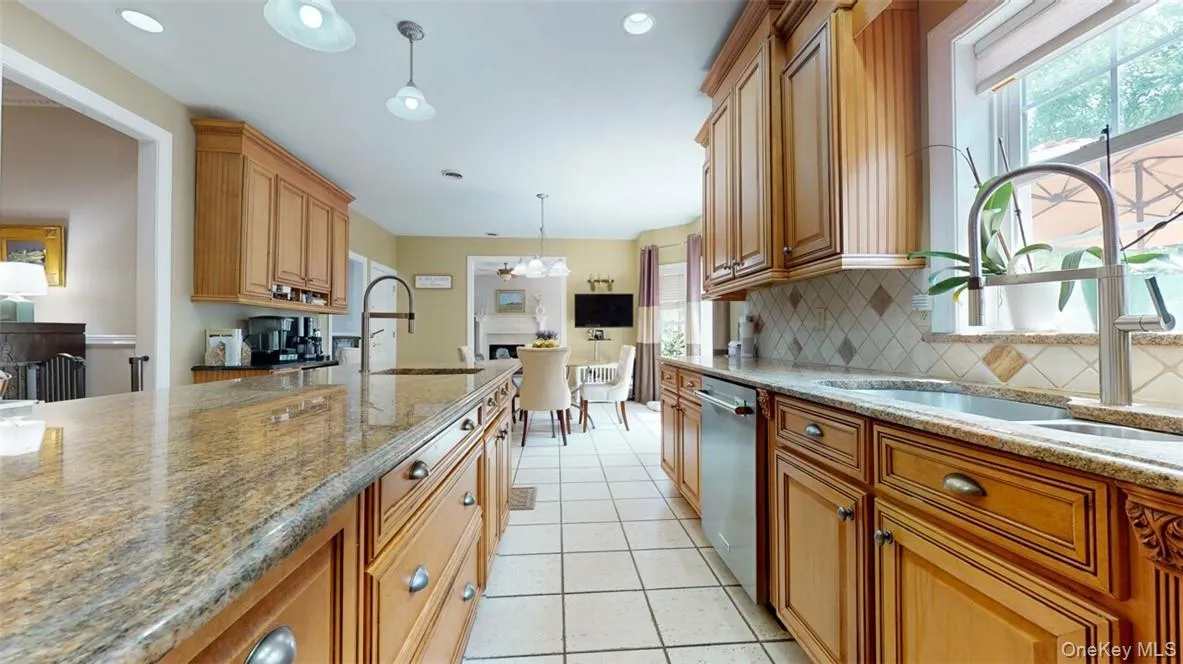 Kitchen with matching designer light fixtures over island and granite kitchen table that seats 5-6,, decorative backsplash, stainless steel dishwasher, 2 sinks. Kitchen with matching designer light fixtures over island and granite kitchen table that seats 5-6,, decorative backsplash, stainless steel dishwasher, 2 sinks.