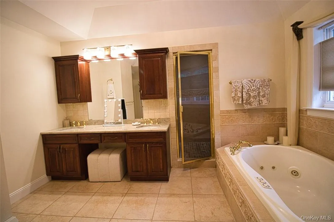 En-Suite Bathroom featuring tray ceiling, large Jacuzzi, marble tile flooring, tumbled marble shower,new sinks, new granite counter, new sink faucets, gorgeous new light fixture and vanity! En-Suite Bathroom featuring tray ceiling, large Jacuzzi, marble tile flooring, tumbled marble shower,new sinks, new granite counter, new sink faucets, gorgeous new light fixture and vanity!
