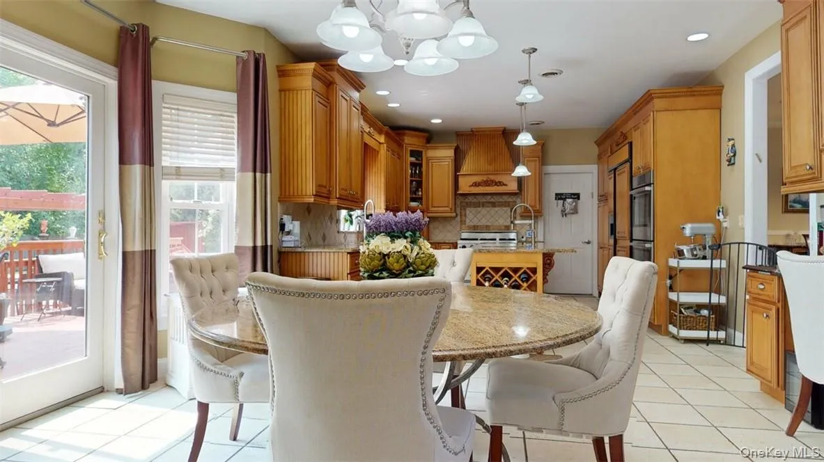 Breakfast area with bay windows, sliders to deck, ceramic tile floors, 8 ft, extra-thick beveled edge granite island with prep sink, big round matching granite Table. Breakfast area with bay windows, sliders to deck, ceramic tile floors, 8 ft, extra-thick beveled edge granite island with prep sink, big round matching granite Table.