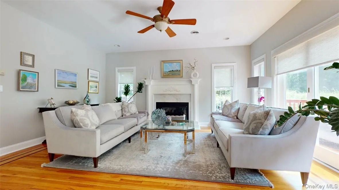 Family Room with light hardwood floors, w/inlay border, a high end fireplace, and ceiling fan Family Room with light hardwood floors, w/inlay border, a high end fireplace, and ceiling fan